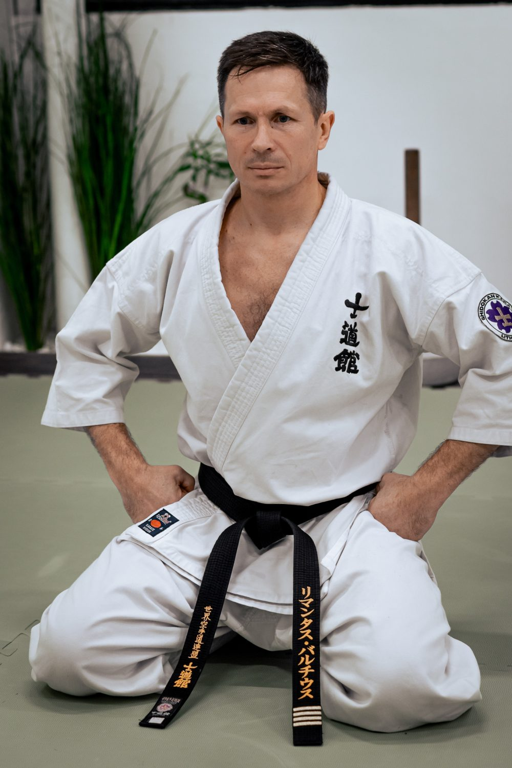 Rimantas Balčius klūpi ant tatamio su baltu gi ir juodu diržu